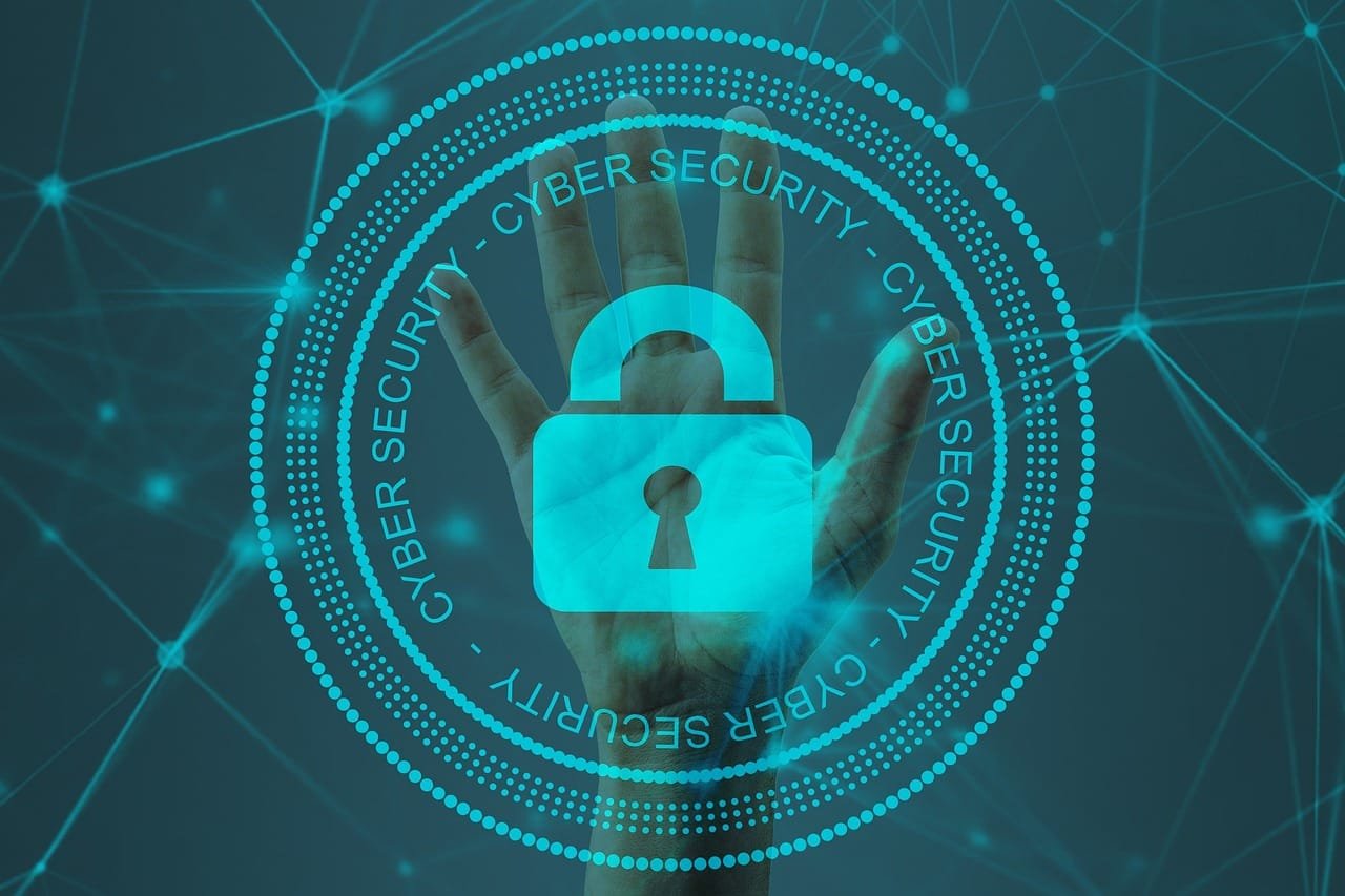 La imagen está relacionada con la Ingeniería en Ciberseguridad, representada a través de
varios elementos visuales que evocan conceptos clave en esta disciplina. Al centro, se ve una
mano levantada con un ícono de candado superpuesto, lo que simboliza la seguridad, la
protección y el control de acceso, temas fundamentales en la ciberseguridad.