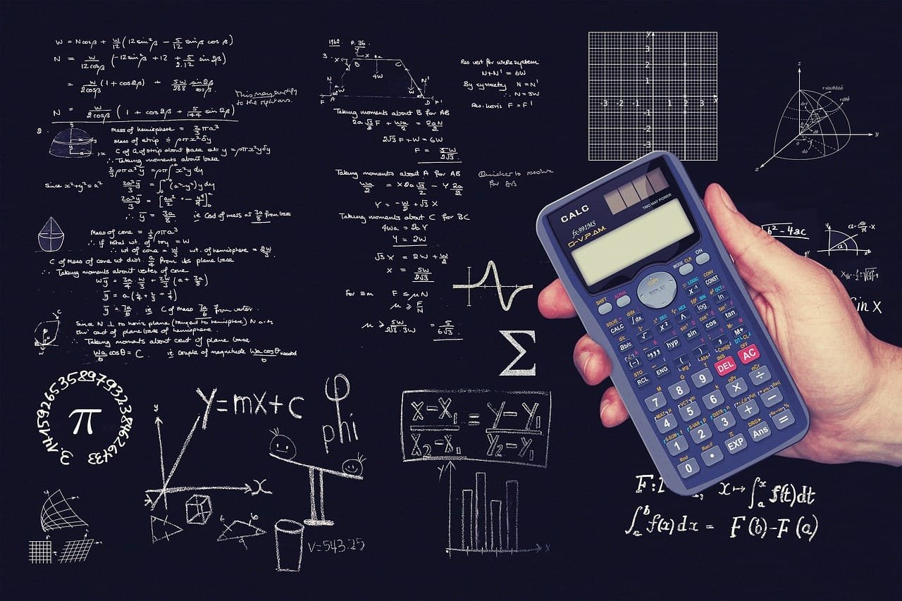 Mano sosteniendo una calculadora científica en primer plano. Al fondo, se observa un
pizarrón o pizarra cubierta de fórmulas matemáticas escritas a mano. Estas fórmulas son
variadas y abarcan diferentes ramas de las matemáticas, como álgebra, geometría, cálculo y
estadística